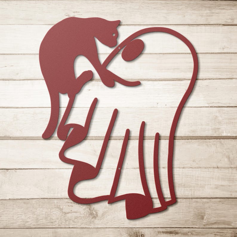 May include: A dark red metal wall art piece featuring a stylised silhouette of a cat perched atop a large heart shape. The design is composed of continuous lines forming the feline figure and the heart outline, creating a flat, cutout aesthetic.