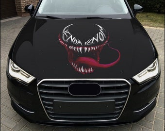 May include: Black car with a Venom graphic on the hood. The graphic is a close-up of Venom's face with his teeth bared and tongue sticking out. The graphic is in white and red.