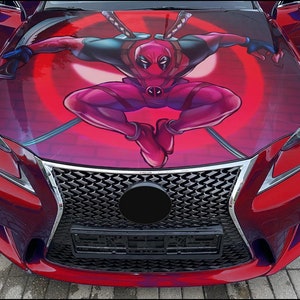 Puede incluir: Un coche rojo con una parrilla negra y un gráfico de Deadpool en el capó. El gráfico es una ilustración roja y negra de Deadpool en una pose de lucha.