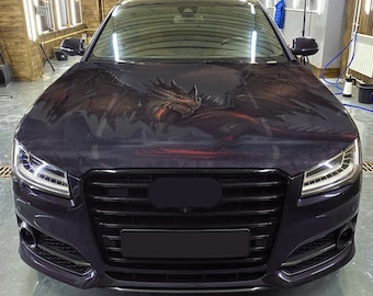 Può includere: Un'Audi nera con una grafica di drago sul cofano. L'auto ha una griglia e fari neri.