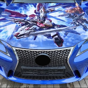 May include: A blue car with a custom anime-style wrap featuring a robot design on the hood. The car has a black grille and headlights.