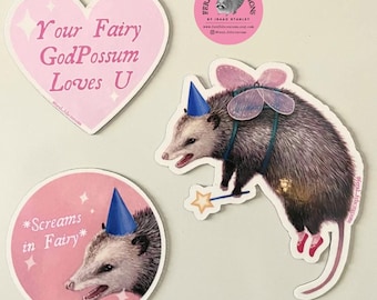 May include: A collection of whimsical stickers featuring opossums. One sticker is heart-shaped with the text "Your Fairy GodPossum Loves U". Another shows an opossum with fairy wings and a wand. A third sticker says "*Screams in Fairy*".