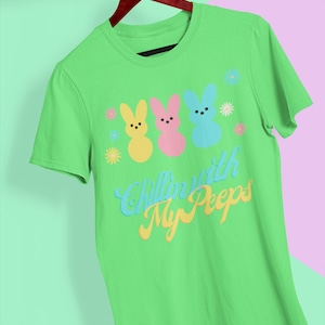 May include: Green t-shirt with a graphic of three pastel-colored Peeps and the text "Chillin' with My Peeps".