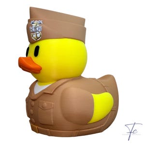 May include: A yellow rubber ducky wearing a brown Navy uniform and hat. The hat has a USN emblem. The duck has an orange beak and black eyes. The duck's uniform has a white collar.