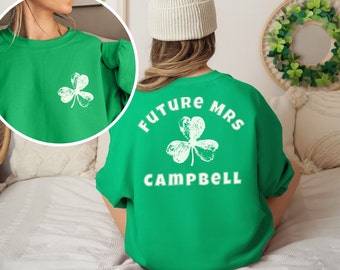 May include: Green sweatshirt with a white shamrock on the front and the text "FUTURE MRS CAMPBELL" with a white shamrock on the back.