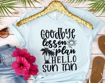 Könnte beinhalten: Hellblaues T-Shirt mit schwarzem Text, der "Goodbye lesson plan hello sun tan" lautet. Das Shirt hängt an einem Kleiderbügel und es sind Palmen und ein Sonnenmotiv auf dem Shirt zu sehen.