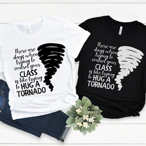 May include: Two t-shirts with a black and white tornado graphic and the text "There are days when trying to control your class is like trying to hug a tornado".