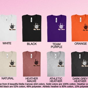 Puede incluir: Ocho camisetas Bella Canvas en varios colores, incluyendo blanco, negro, morado equipo, naranja, natural, malva jaspeado, jaspeado atl&eacute;tico y gris oscuro jaspeado. Cada camiseta presenta una mano de esqueleto negra haciendo el dedo medio con el texto "life sucks" debajo.