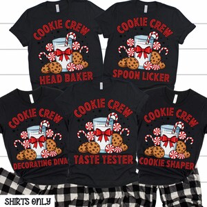 May include: Black t-shirts with the text "COOKIE CREW" in red. Each shirt features a graphic of a glass of milk with a red bow, candy canes, cookies, and candies. The shirts have different titles: "Head Baker", "Spoon Licker", "Decorating Diva", "Taste Tester", and "Cookie Shaper".