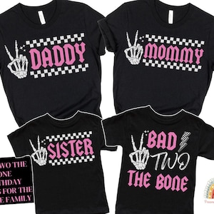 K&ouml;nnte beinhalten: Schwarze T-Shirts mit rosa und wei&szlig;em Text. Die Shirts sagen "Daddy", "Mommy", "Sister" und "Bad Two The Bone".