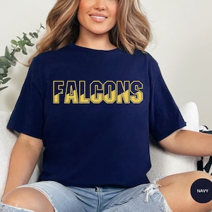 May include: A navy blue t-shirt with the word "FALCONS" printed in yellow on the front.