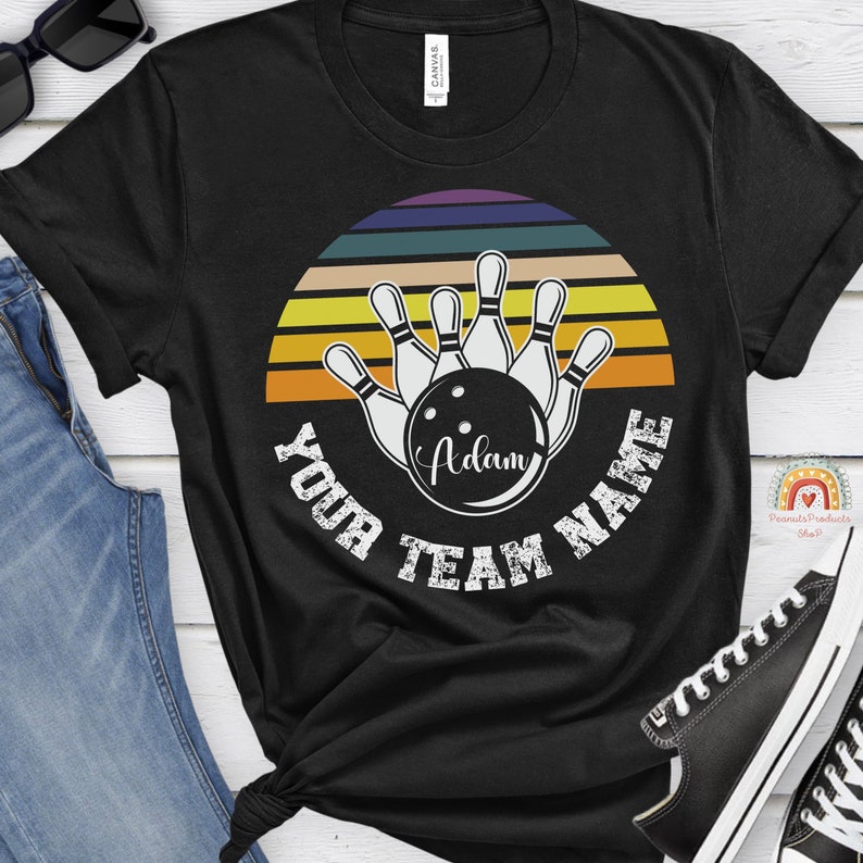 K&ouml;nnte beinhalten: Schwarzes T-Shirt mit einem Retro-Sonnenuntergangsdesign mit Bowling-Pins und einer Bowlingkugel mit dem Text "Your Team Name". Die Bowlingkugel tr&auml;gt den Namen "Adam".