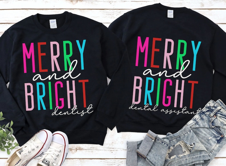 May include: Two black sweatshirts with the text "Merry and Bright" in colorful letters. One sweatshirt says "dentist" and the other says "dental assistant".