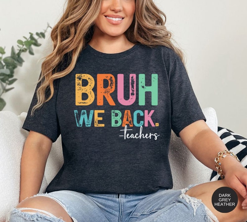 May include: Dark grey heather t-shirt with the text "BRUH WE BACK. -teachers" in rainbow colors.