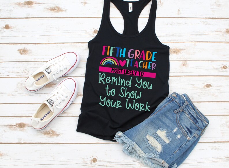K&ouml;nnte beinhalten: Schwarzes Tanktop mit dem Text "Fifth Grade Teacher Most Likely To Remind You To Show Your Work" in bunten Buchstaben mit einem Regenbogen und einem Herz-Motiv.