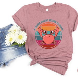 May include: Heather mauve t-shirt with a retro-style graphic of a crab with the text "If Crabby Please Return to Beach".