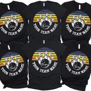 K&ouml;nnte beinhalten: Sechs schwarze T-Shirts mit einem Retro-Bowlingball-Design und dem Text "Your Team Name". Jedes Shirt zeigt einen anderen Namen auf dem Bowlingball.