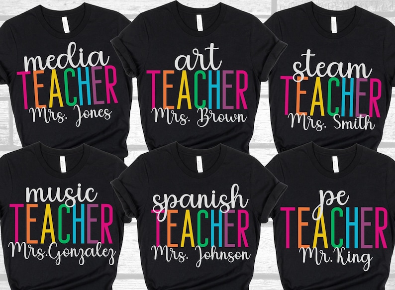 K&ouml;nnte beinhalten: Sechs schwarze T-Shirts mit buntem Text, der "media teacher Mrs. Jones", "art teacher Mrs. Brown", "steam teacher Mrs. Smith", "music teacher Mrs. Gonzalez", "spanish teacher Mrs. Johnson" und "pe teacher Mr. King" lautet.