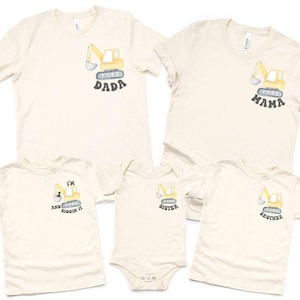 May include: Cream-colored t-shirts and a onesie featuring a yellow excavator design. The shirts have text that says "DADA", "MAMA", "I'M AND BUGGIN IT", "SISTER", and "BROTHER".