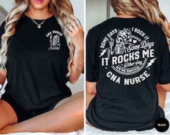 May include: Black t-shirt with a white graphic of a skeleton wearing a nurse's cap and holding a lightning bolt. The text "Some Days I Rock It Some Days It Rocks Me Either Way We're Rockin' CNA NURSE" is printed around the skeleton. The text "CNA NURSE" is printed on the front of the shirt.