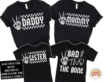May include: Black t-shirts with white text and graphics. The shirts say "Daddy", "Mommy", "Sister", and "Bad Two The Bone".