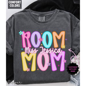 May include: Dark gray Comfort Colors t-shirt with the words "ROOM Miss Jessica MOM" in colorful, playful lettering. The design includes floral accents and the option to customize with any name.