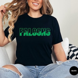 May include: A black t-shirt with a green graphic that says "FALCONS".