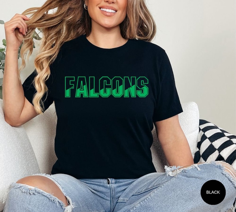 May include: A black t-shirt with a green graphic that says "FALCONS".