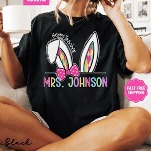 May include: Black t-shirt with a white bunny ear design and the text "Hoppy Teacher" above the text "MRS. JOHNSON".