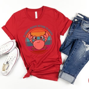 May include: Red t-shirt with a retro-style graphic of a crab with the text "If Crabby Please Return to Beach".
