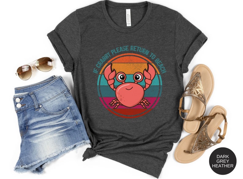 May include: Dark grey heather t-shirt with a retro-style graphic of a crab with the text "If Crabby Please Return to Beach".