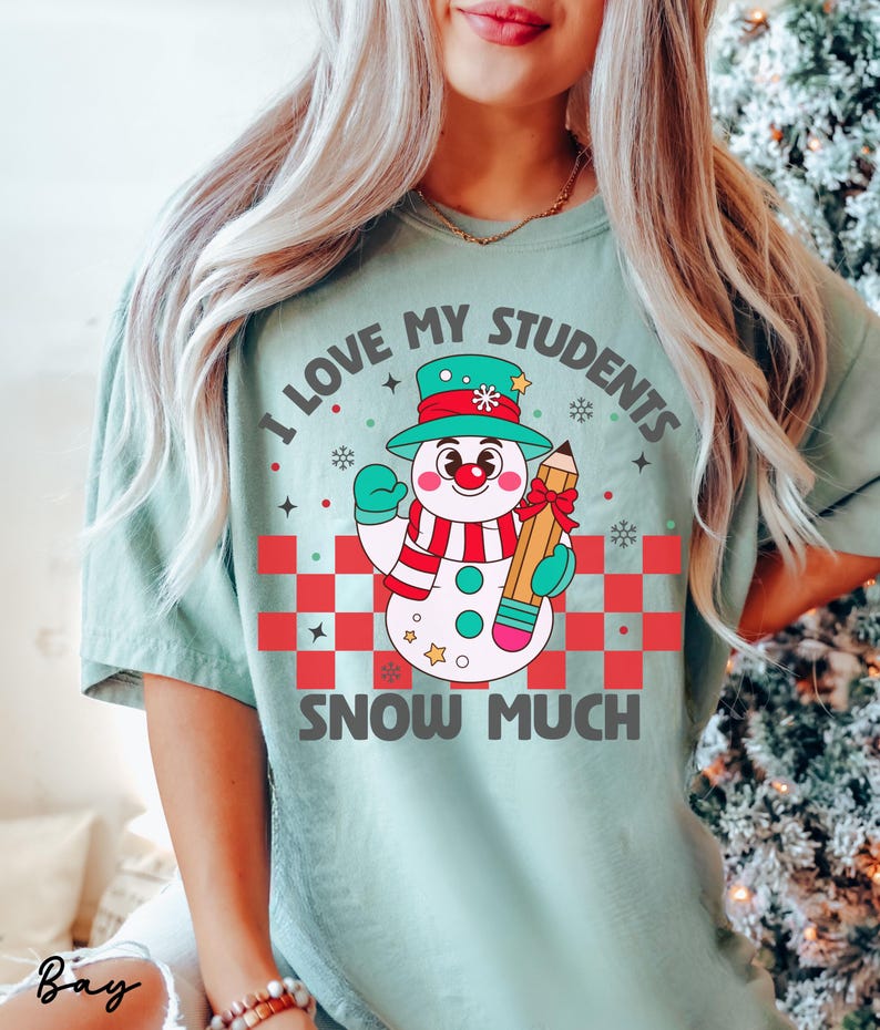 May include: A teal blue t-shirt with a snowman holding a pencil and the text "I love my students snow much".