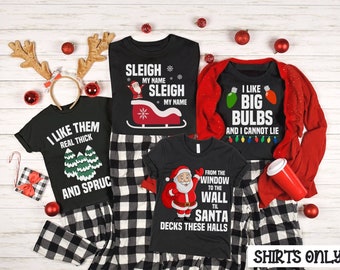May include: Four black t-shirts with Christmas-themed designs. The shirts feature phrases like "I like them real thick and spruce", "Sleigh my name", "I like big bulbs and I cannot lie", and "From the window to the wall til Santa decks these halls".