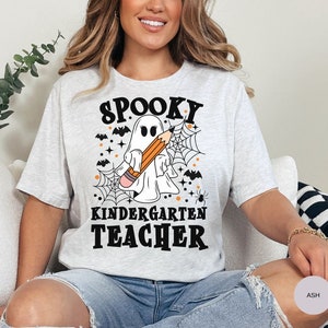 May include: A gray t-shirt with a spooky ghost holding a pencil and the text "Spooky Kindergarten Teacher".