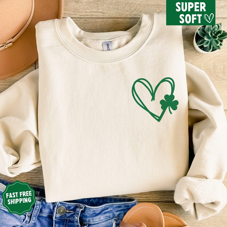 May include: A cream coloured sweatshirt with a green heart and shamrock design. The sweatshirt is super soft and comfortable.