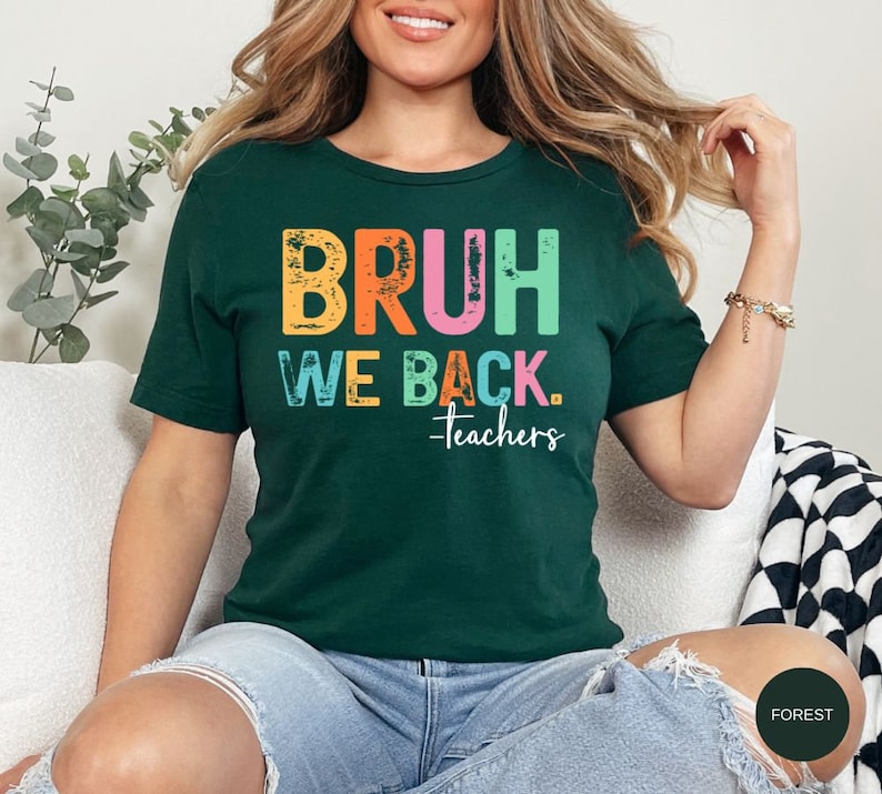 May include: A green t-shirt with the text "BRUH WE BACK. -teachers" in rainbow colors. The text has a distressed, vintage look.