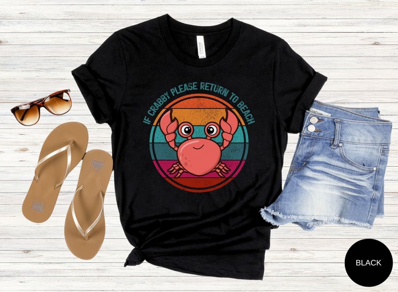 May include: Black t-shirt with a retro-style graphic of a crab with the text "If Crabby Please Return To Beach".