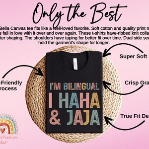 Puede incluir: Camiseta negra con un gr&aacute;fico de estilo vintage que dice "I'm Bilingual I Haha & Jaja". La camiseta est&aacute; sobre un fondo tejido con texto alrededor que dice "Only the Best", "Super Soft Feel", "Eco-Friendly Process", "Crisp Graphic", y "True Fit Design".