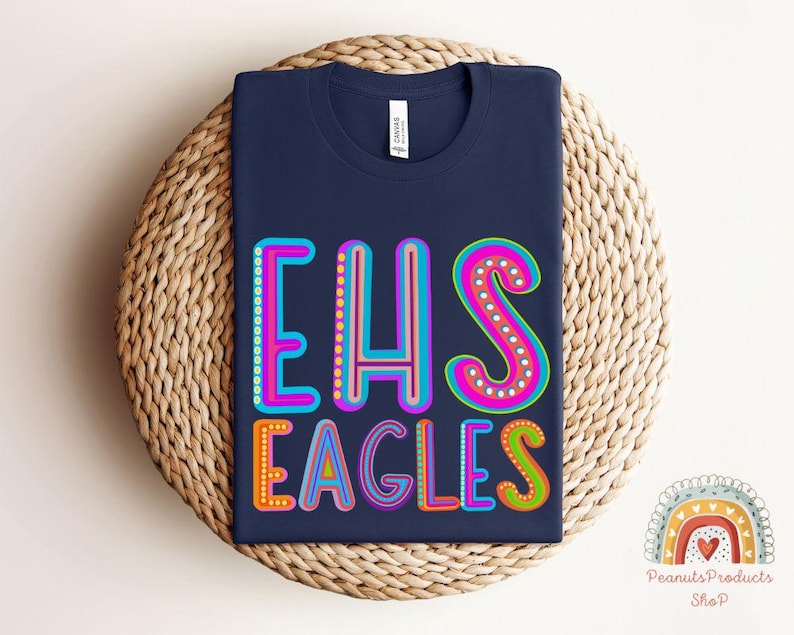 Puede incluir: Camiseta azul marino con un gr&aacute;fico colorido que dice "EHS Eagles".
