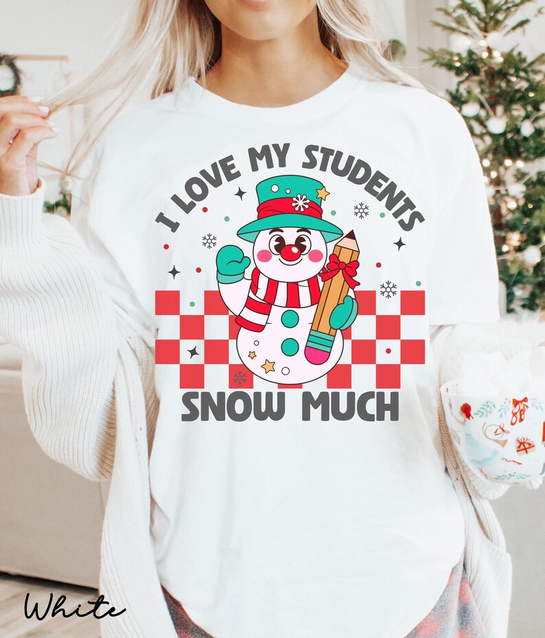 May include: White t-shirt with a snowman holding a pencil and the text "I love my students snow much".