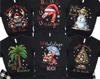 May include: Black graphic t-shirts with holiday-themed designs. Designs include a crab in a Santa hat, a flamingo in a Santa hat, a snowman at the beach, a palm tree, Santa at the beach, and a Christmas tree made of shells. The text "SHIRTS ONLY" is at the bottom.