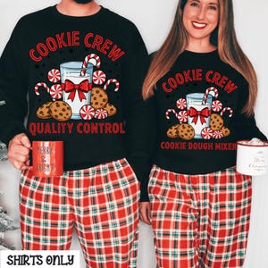 May include: Black sweatshirts with the text "Cookie Crew" and a graphic of milk, cookies, and candy canes. The sweatshirts are paired with red plaid pajama pants. One person holds a red mug that says "Merry & Bright".