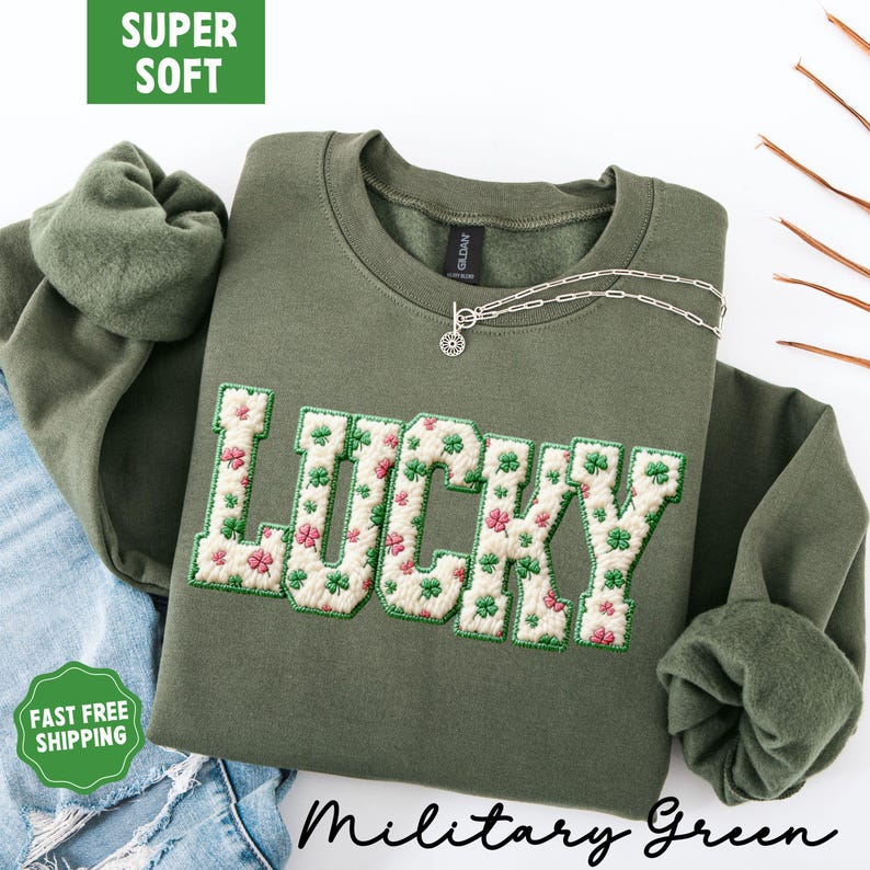 Pu&ograve; includere: Felpa verde militare con la scritta "LUCKY" ricamata con un motivo floreale a trifogli. La felpa ha un girocollo e maniche lunghe. Le parole "SUPER SOFT" e "FAST FREE SHIPPING" sono nell'immagine.