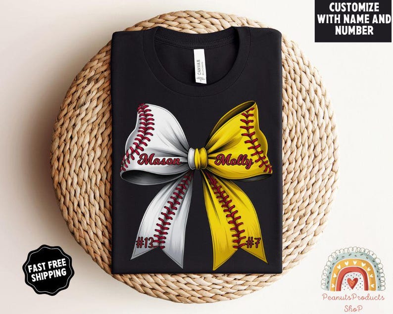 May include: Black t-shirt with a white and yellow softball bow with red stitching. The bow has the names "Mason" and "Molly" written on it. The numbers "#13" and "#7" are also on the bow.