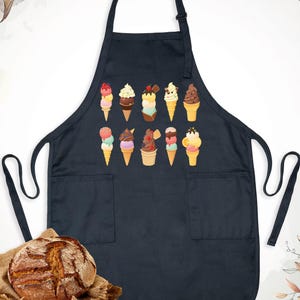 May include: A dark blue kitchen apron with a variety of colorful ice cream cones printed on the front. The apron has two large pockets on the front.