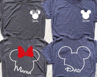 May include: Four grey and blue t-shirts with a white outline of Mickey Mouse ears. The shirts have the words "Mama", "Dad", "Denise", and "Jackson" printed on them.