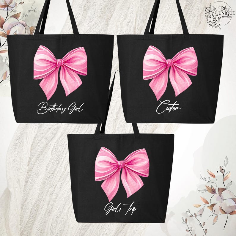 May include: Black tote bags with large pink bow designs. One bag reads "Birthday Girl", another "Custom", and the third "Girls Trip". The bags have long black handles and are likely made of canvas or a similar material.
