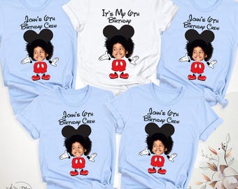 Könnte beinhalten: Eine Sammlung von fünf kurzärmeligen T-Shirts in Hellblau und Weiß. Jedes Shirt zeigt das Gesicht eines Kindes auf einem Cartoon-Mauskörper mit schwarzen Ohren, roten Shorts und weißen Handschuhen. Der Text lautet John's 6th Birthday Crew oder It's My 6th Birthday.