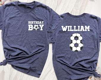 May include: A heather navy blue t-shirt featuring the white text BIRTHDAY BOY with a soccer ball graphic replacing the letter O on the front, and the name WILLIAM above a large soccer ball graphic shaped like the number 8 on the back.