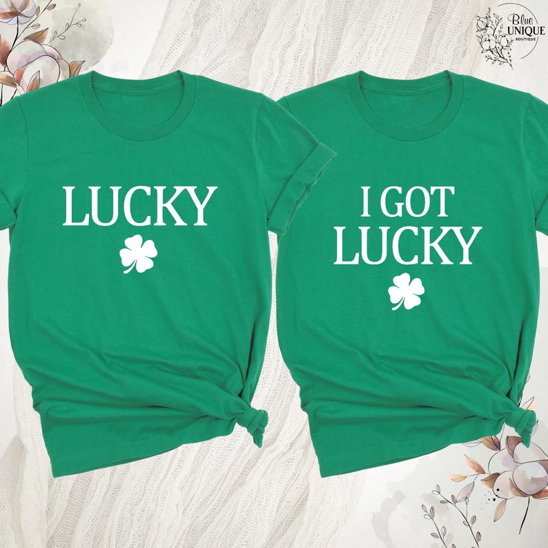 K&ouml;nnte beinhalten: Zwei gr&uuml;ne T-Shirts mit wei&szlig;em Text und einem Kleeblatt-Design. Ein Shirt sagt "LUCKY" und das andere sagt "I GOT LUCKY". Die Shirts sind aus einem weichen Material und perfekt f&uuml;r St. Patrick's Day.